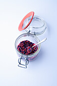 Borage flowers and freeze-dried red berries in a jar