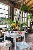 Gartenhaus im Landhausstil mit Pflanzen und gedecktem Tisch