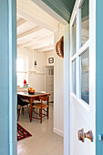 View through the door into the dining room with wooden table and assorted chairs