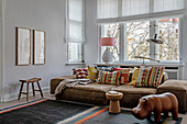 Living room with large leather sofa and patterned cushions