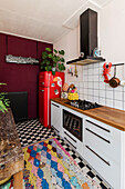 Small kitchen with retro fridge and black and white floor tiles