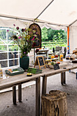 Rustic wooden table with flowers, juices and biscuits in a garden pavilion