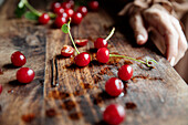 Red cherries and hairpin on wooden board