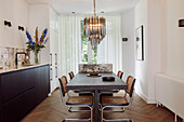 Dining table with rattan chairs and pendant light in modern kitchen
