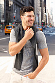 Sportily dressed young man with glasses on the street