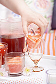 Summery drinks with grapefruit slices and flower decoration on a white tray