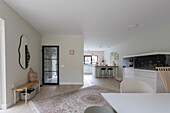 Open, bright living room with a view into the kitchen