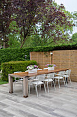 Holztisch mit Metallstühlen auf einer Terrasse