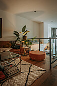 Gallery living room with leather sofa, glass table and indoor plants