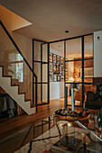 Modern living room with glass walls and wooden staircase