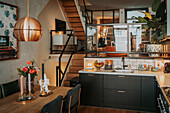 Open-plan living room with modern kitchen and wooden staircase