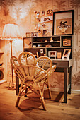 Desk corner with rattan chair and retro-style palm wallpaper