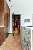 Kitchen with herringbone floor and open glass door to the hallway