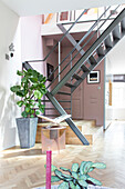 Metal staircase, plants and pictures in a modern living room