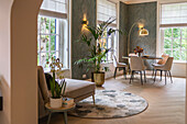 Cosy dining area and reading corner with large windows and indoor plants