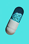 Close up granules inside medicine capsule on blue background\n