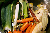 Fresh vegetables and cinnamon stick cooking in pot\n