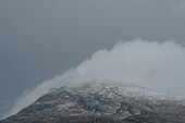 Wolken über einem schneebedeckten Berg, Assynt, Sutherland, Schottland