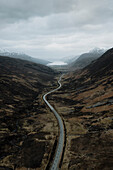 Kurvenreiche Straße durch einsame Hügel in majestätischer Landschaft, Kinlochewe, Torridon, Schottland