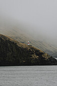 Lighthouse on cliff above sea, Bour, Vagar, Faroe Islands\n