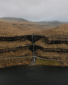 Three-tier waterfall flowing over cliff into sea, Fossa, Haldarsvik, Faroe Islands\n