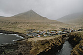 Remote village below foggy hill, Gjogv, Eysturoy, Faroe Islands\n