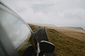 Auto fährt auf der Straße in abgelegener Landschaft, Lopra, Suduroy, Färöer Inseln