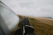 Car driving on road in remote landscape, Lopra, Suduroy, Faroe Islands\n