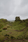 Felsformation Ring in grasbewachsener zerklüfteter Landschaft, Fairy Glen, Isle of Skye, Schottland