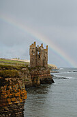 Regenbogen hinter der Burgruine auf der Klippe über dem Meer, Keiss, Schottische Highlands, Schottland