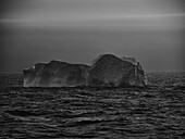 Mysterious gray iceberg on ocean surface off Antarctic Peninsula, Weddell Sea, Antarctica\n