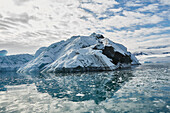 Melting iceberg on sunny blue ocean surface off Antarctic Peninsula, Weddell Sea, Antarctica\n