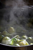 Brussels sprouts cooking in a pan of boiling water\n