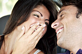 Close up of young couple laughing\n