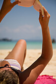 Nahaufnahme einer jungen Frau beim Lesen eines Buches am Strand, Koh Phi Phi, Thailand