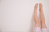 One pair of legs up a white wall\n