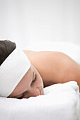 Close up of young woman lying on stomach and relaxing after beauty treatment\n