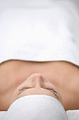 Close up of young woman lying on back and relaxing after beauty treatment\n