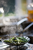 Green beans steaming in a stainless steel steamer\n