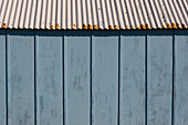 Extreme close up of light blue beach hut and blue sky\n