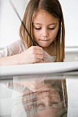 Close up of young girl writing\n