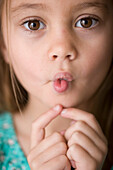 Close up of young girl pulling face\n