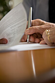 Close up of woman hands signing documents\n