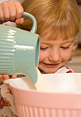 Young girl baking in kitchen\n