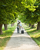 Young couple walking with suitcase and kissing\n
