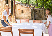 Mother and daughter setting table, Serra San Quirico, Ancona Italy\n