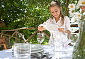 Portrait of young girl polishing glass with dish towel\n