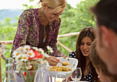 Mother serving pasta to daughter\n