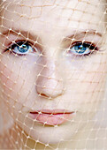 Extreme close up of young beautiful woman wearing net on face\n