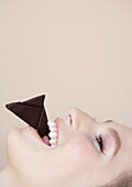Nahaufnahme einer schönen jungen Frau beim Schokolade essen